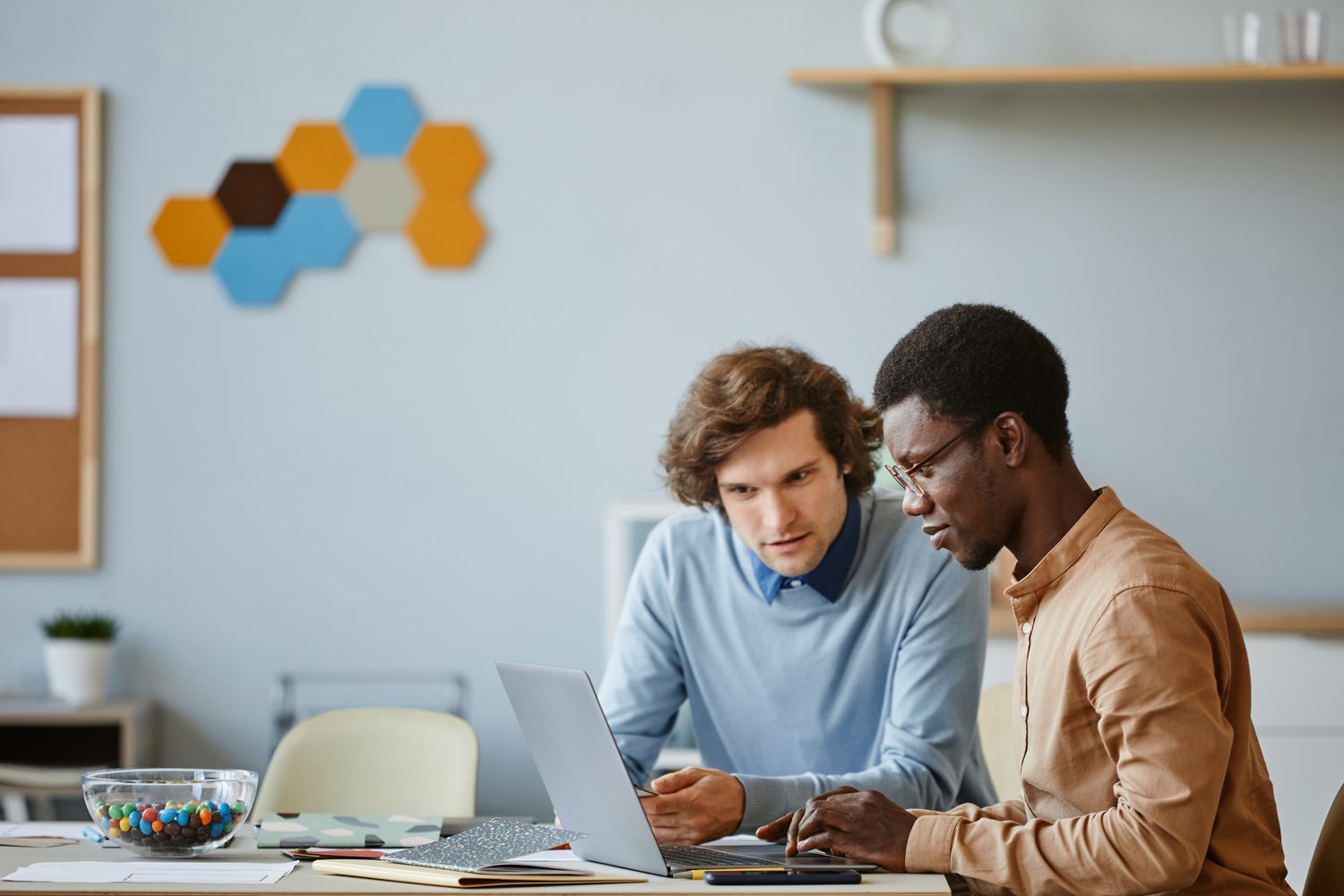 Two engineers collaborating on a laptop, representing custom AI solution design.