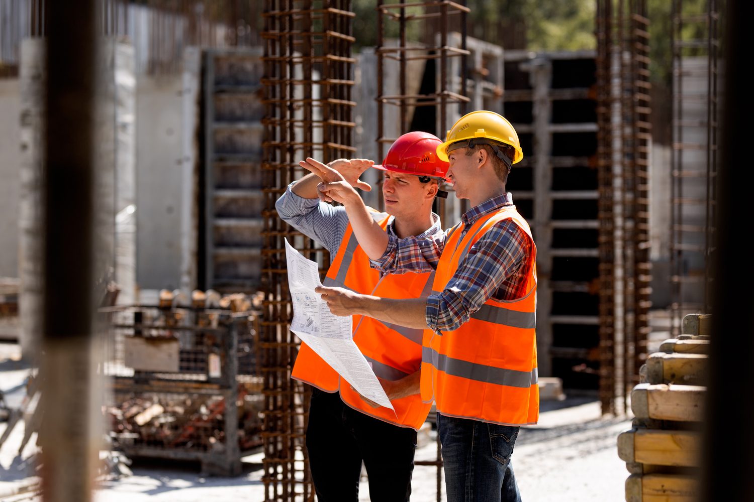 Construction managers reviewing blueprints on site, representing progress claims and payment applications.